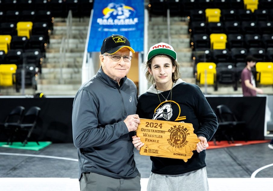 Kaneland’s Angelina Gochis, Outstanding Wrestler, poses for a photo with Dan Gable at 110 pounds during the finals at Dan Gable Donnybrook high school girls wrestling tournament, Friday, Dec. 6, 2024, at Xtream Arena in Coralville, Iowa. MANDATORY CREDIT: Joseph Cress/Think Iowa City